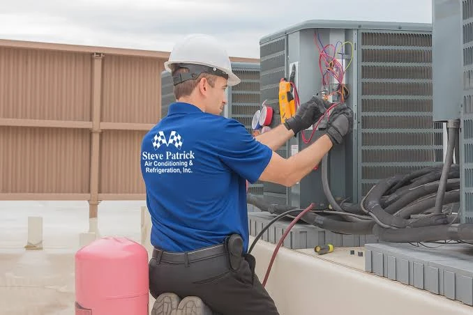 Technician using a meter to test outdoor HVAC equipment